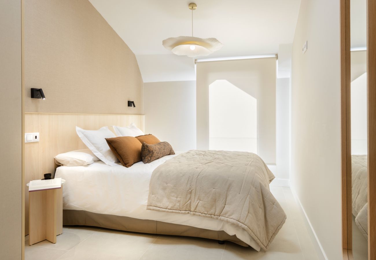 Dormitorio moderno con diseño actual, cama confortable y decoración elegante en apartamento vacacional de Panticosa. 