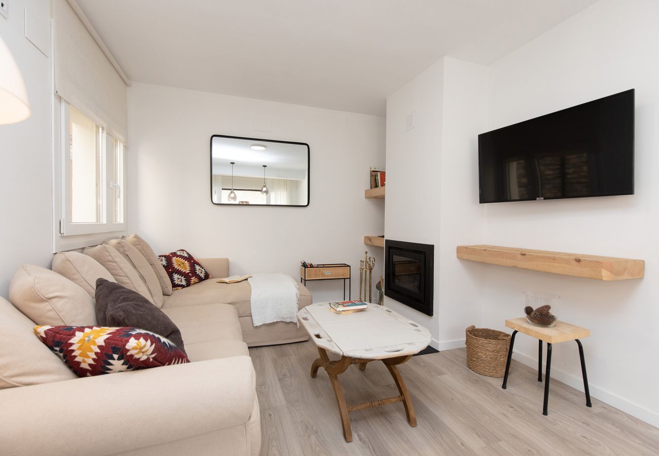 Acogedor salón de estilo contemporáneo con excelente iluminación natural y chimenea integrada de Biescas.