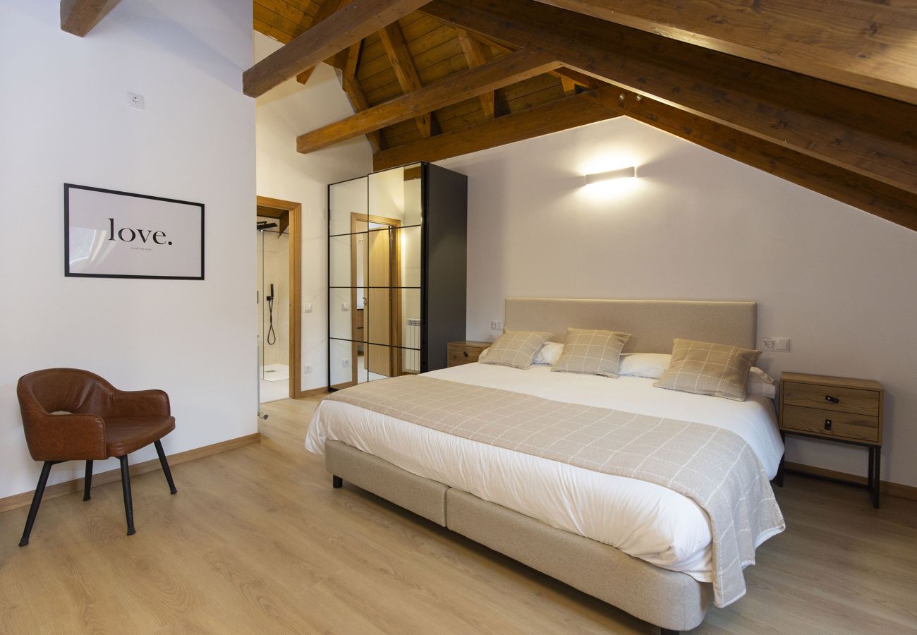 Dormitorio con techo abuhardillado en apartamento de montaña en Panticosa.
