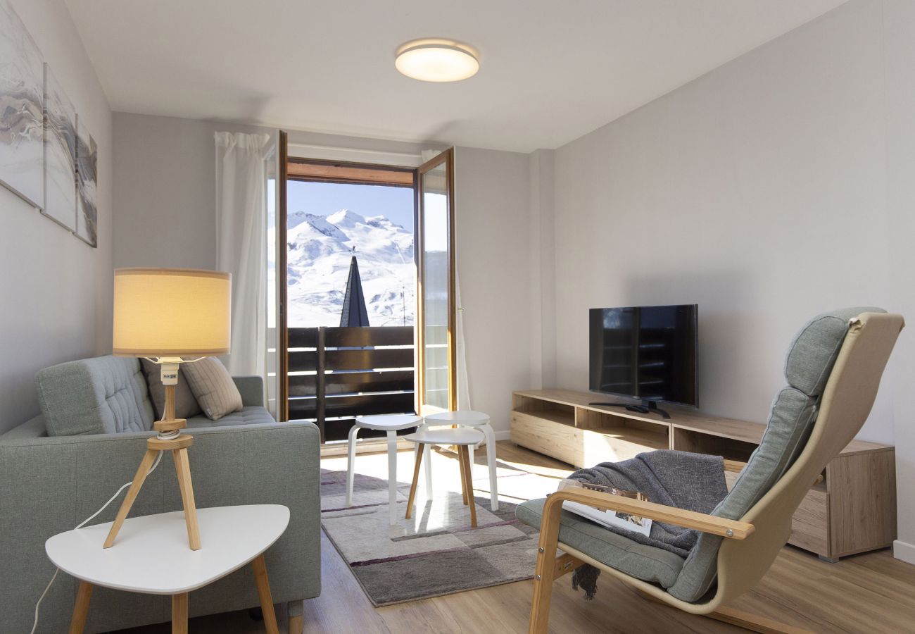 Salón con vistas a la montaña con luz natural en apartamento turístico en Formigal. 