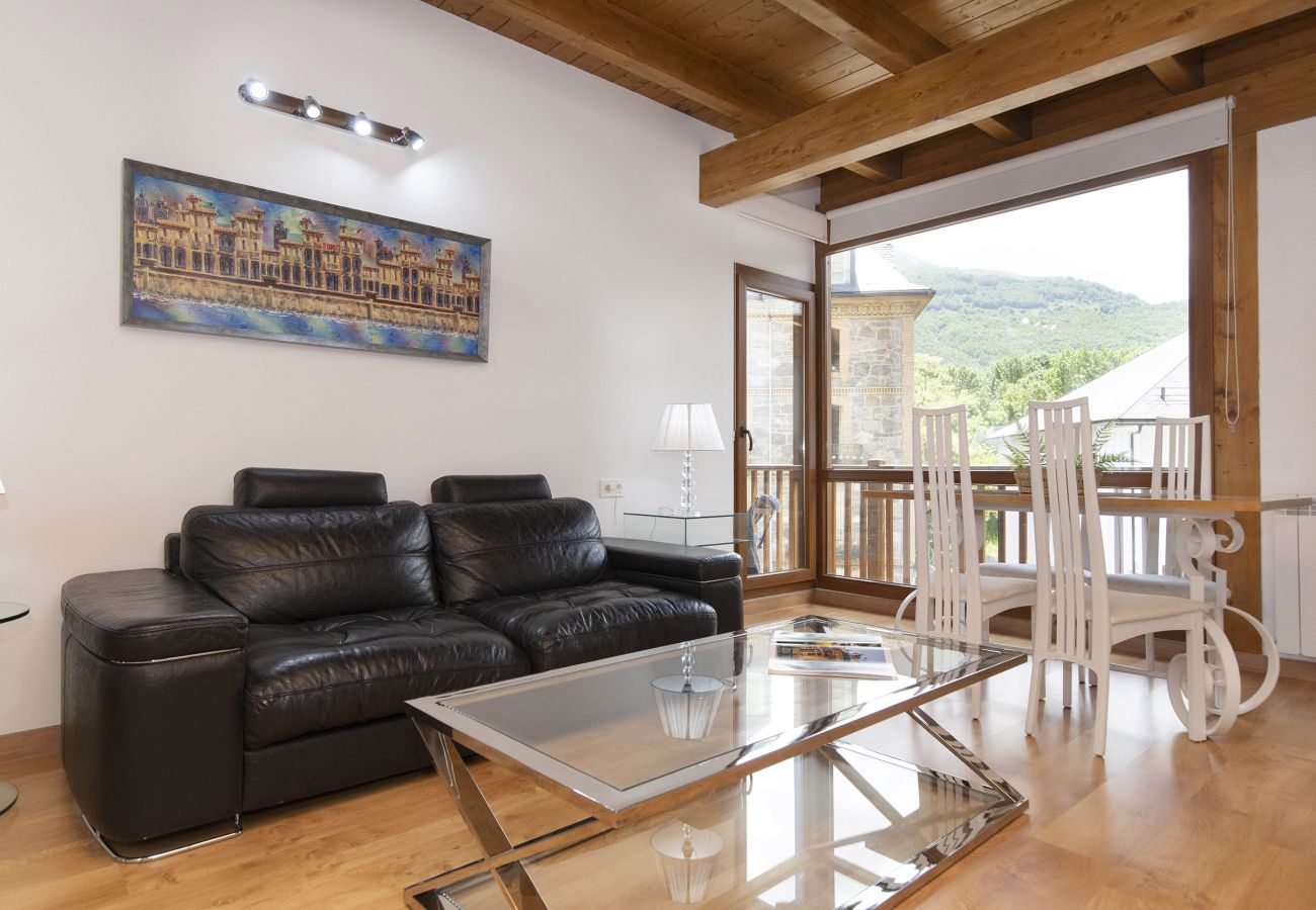 Acogedor salón en el Pirineo con luz natural, diseño cálido en Panticosa.