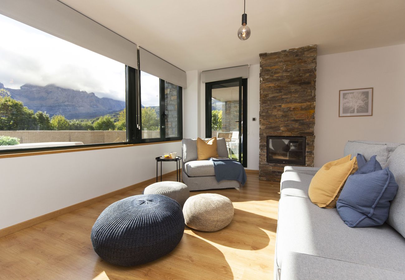 Salón comedor amplio y luminoso con grandes ventanales, vistas a la montaña y ambiente acogedor en Panticosa.