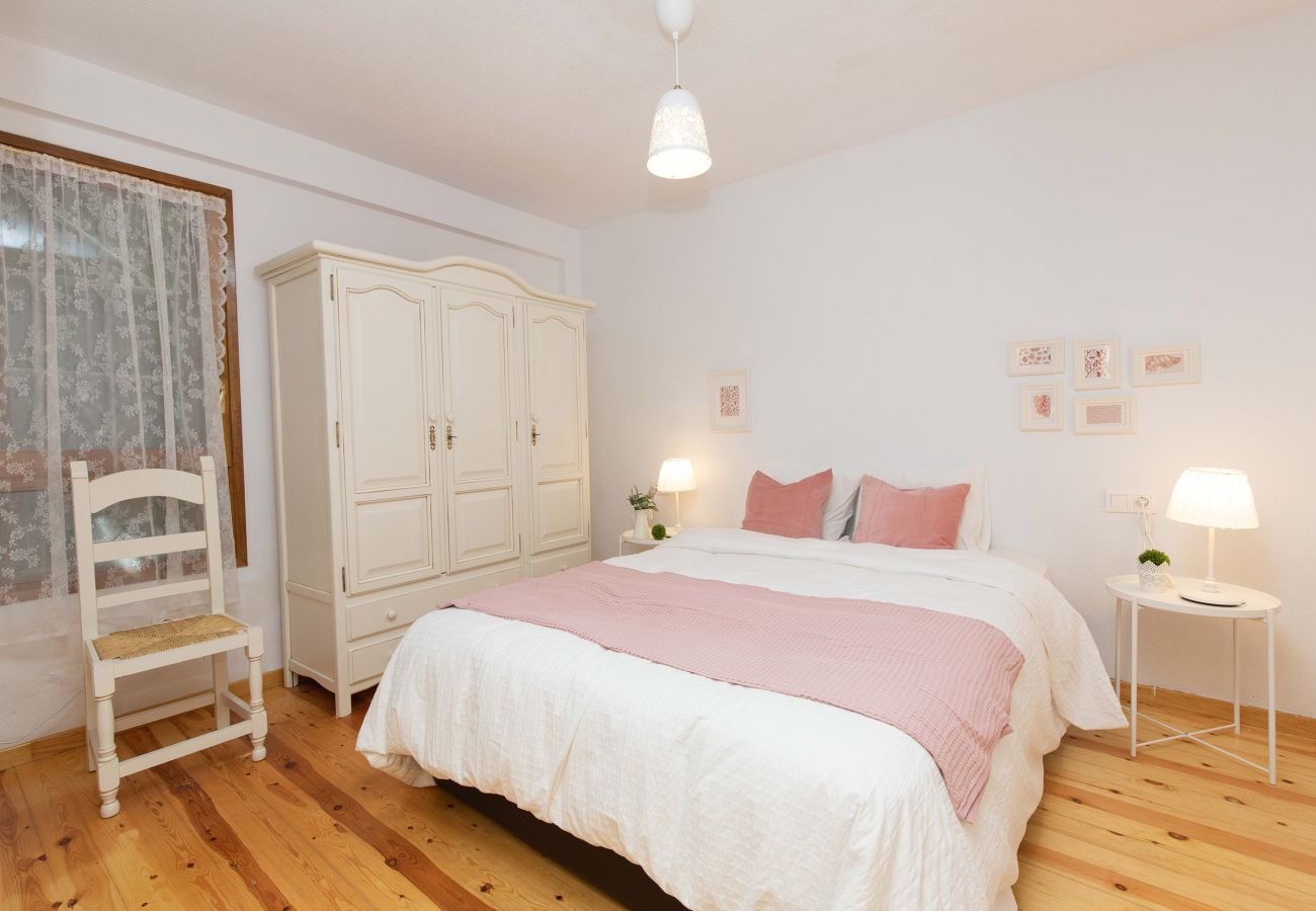 Dormitorio con cama de matrimonio y ambiente cálido, ideal para descansar en plena tranquilidad en El Pueyo de Jaca.