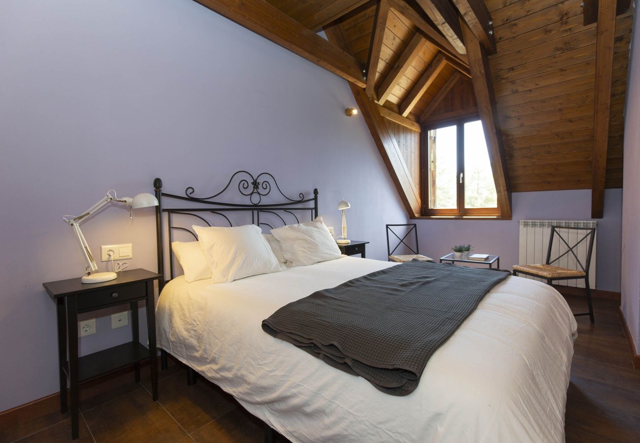 Dormitorio principal con cama de matrimonio, estilo acogedor y ambiente tranquilo en Panticosa. 