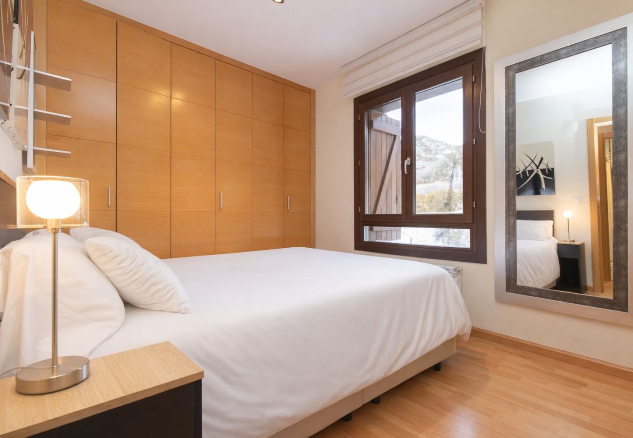 Acogedor dormitorio en Panticosa con luz natural y diseño sencillo, perfecto para un descanso reparador.