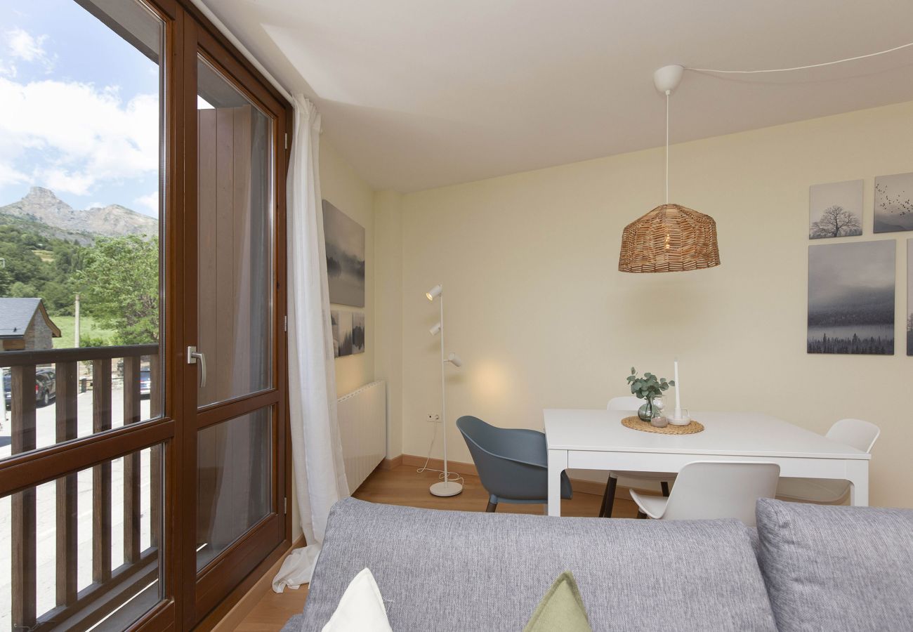 Salón en Escarrilla con luz natural y decoración cálida, ideal para descansar en familia o con amigos.