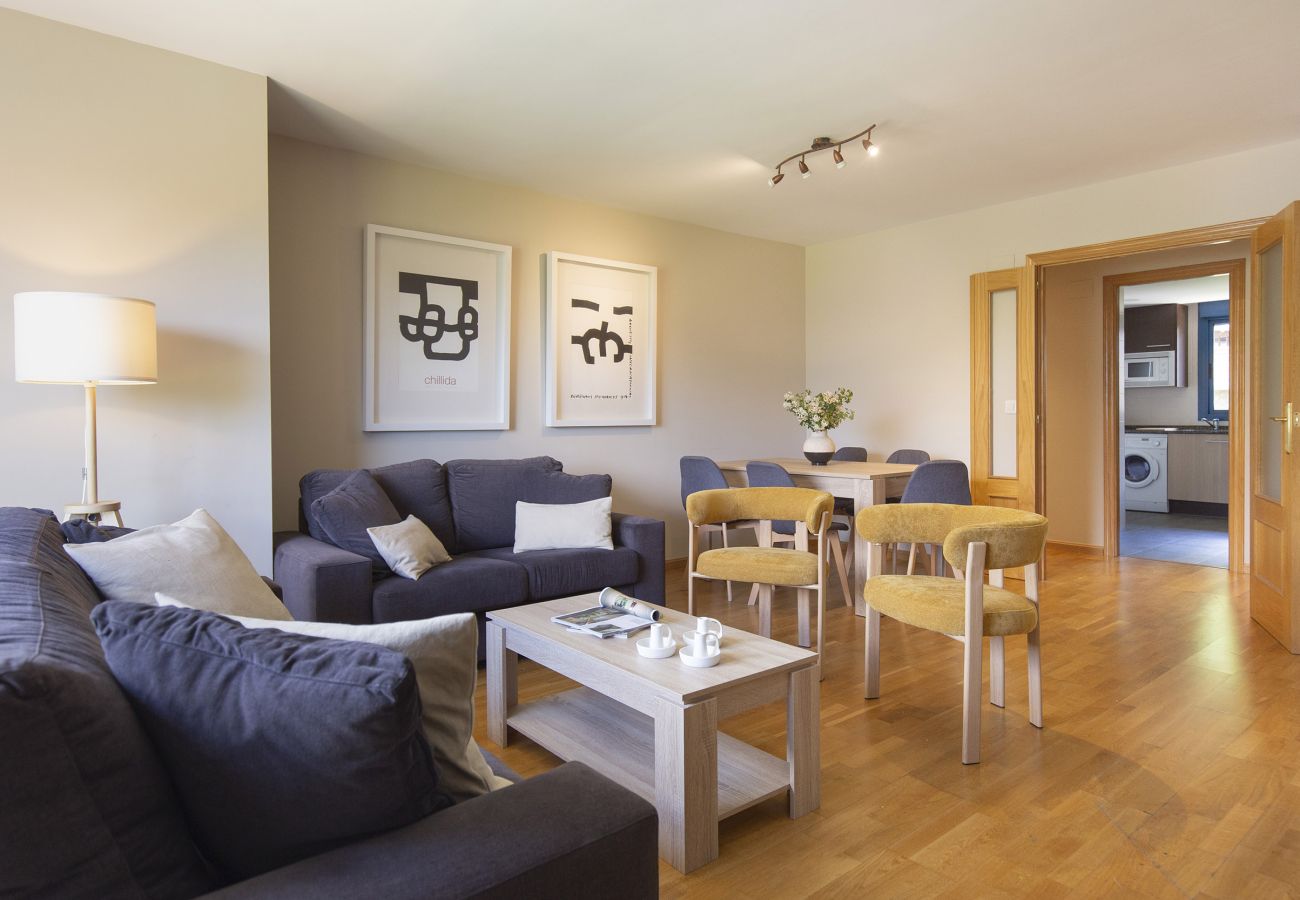 Acogedor salón en el Pirineo con luz natural, diseño cálido y espacio perfecto para descansar en familia.