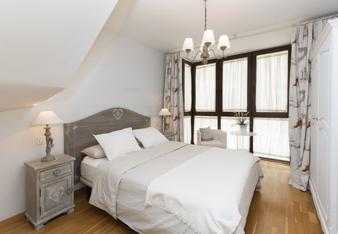 Modern and cozy bedroom with elegant design, natural lighting, and a comfortable atmosphere in Panticosa.