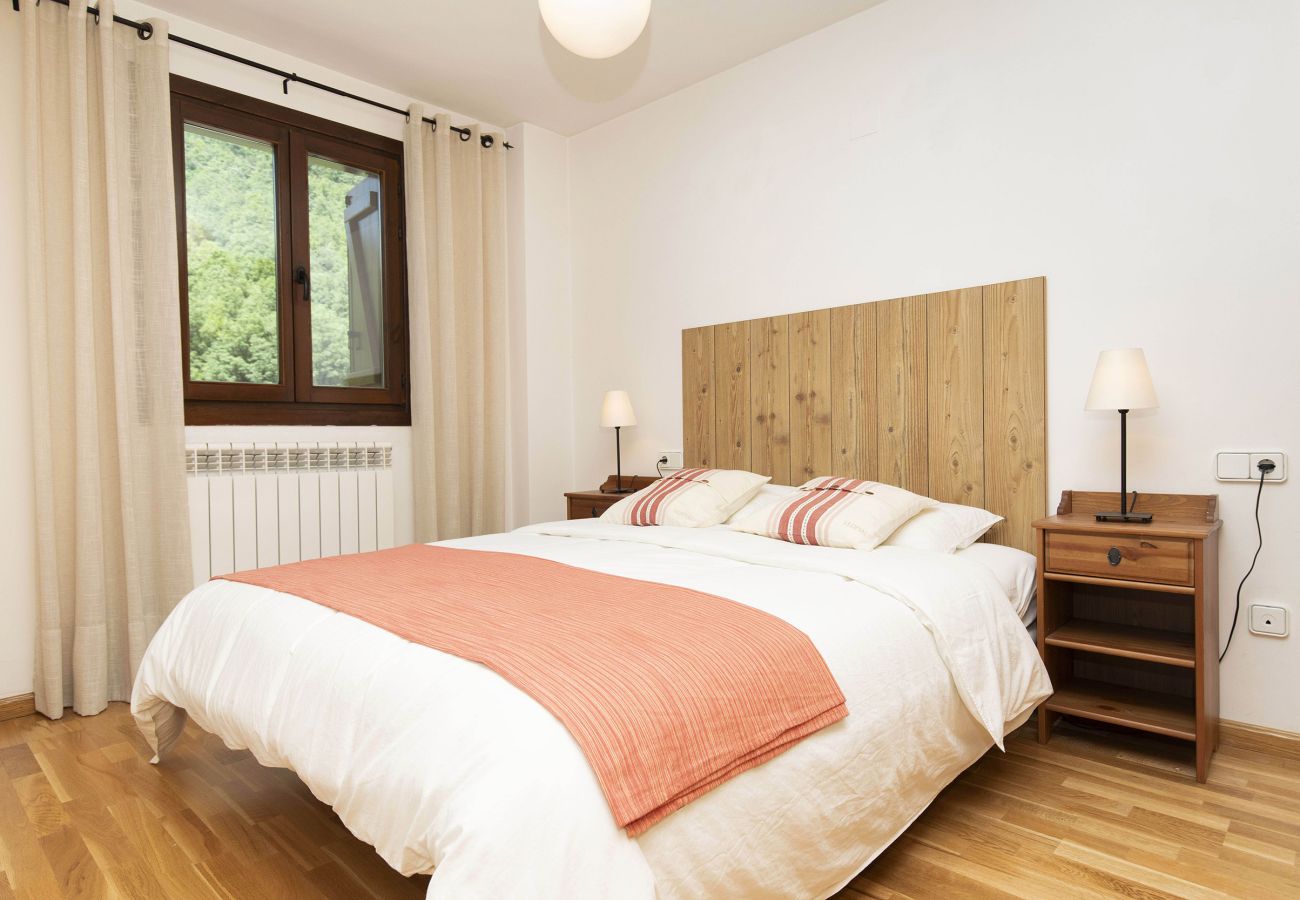 Comfortable bedroom with a double bed, designed for rest and relaxation in a mountain setting in Escarrilla.